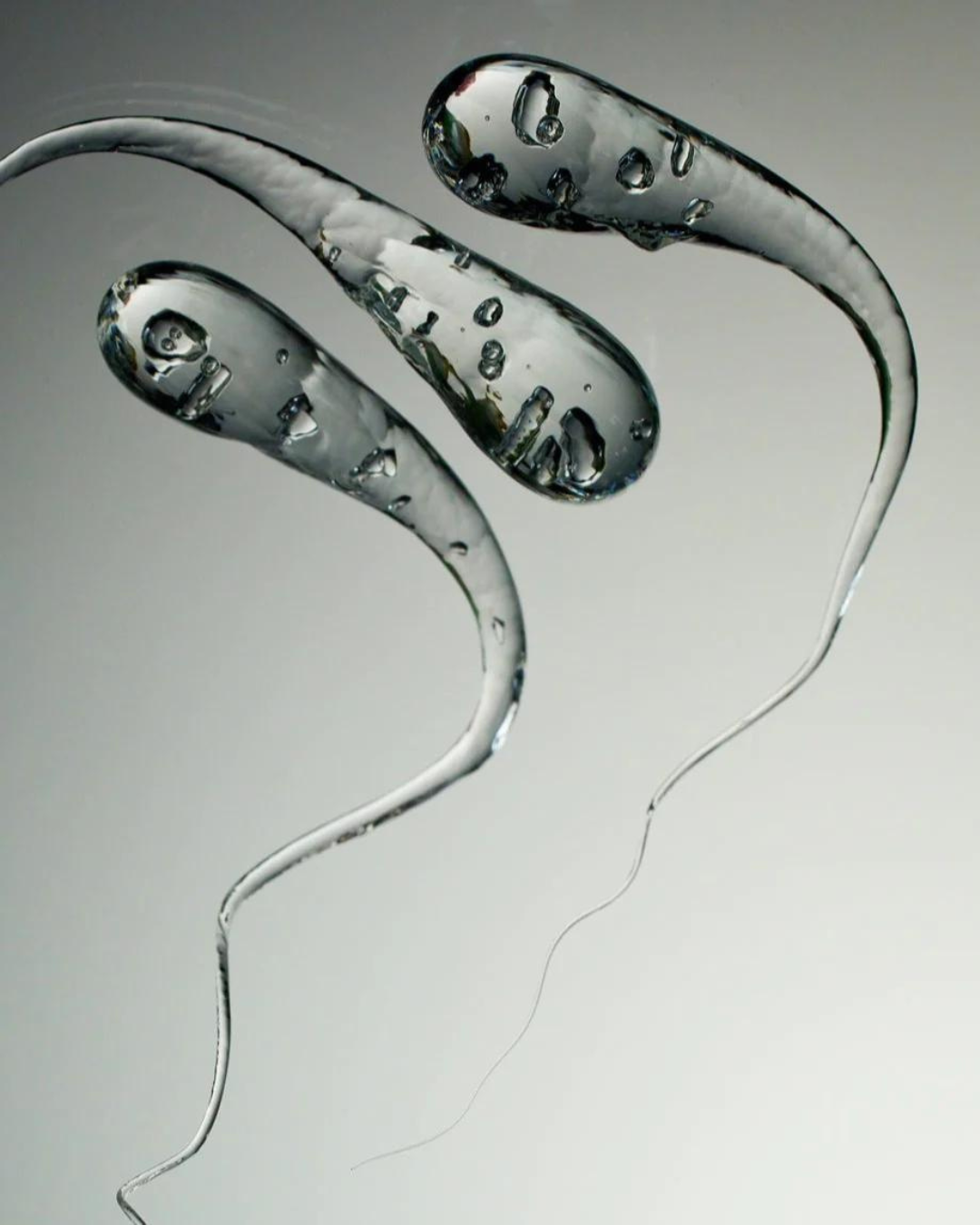 A close-up view of a handmade Prince Rupert’s Drop showcasing its smooth teardrop shape and delicate tail.