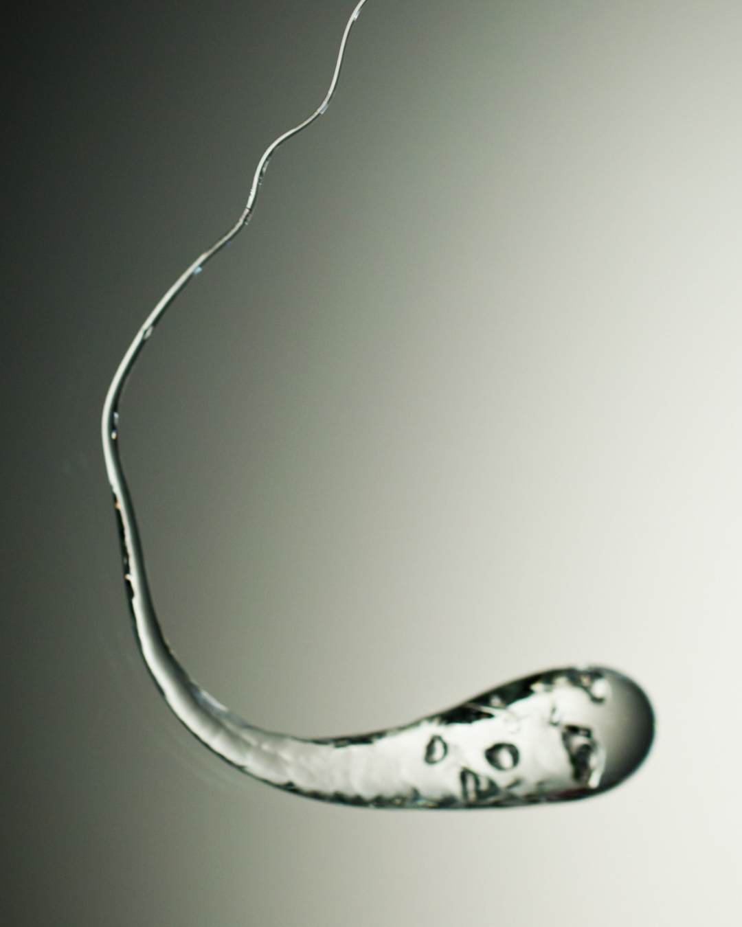 A single Prince Rupert’s Drop held in a hand, illustrating its size and intricate craftsmanship.